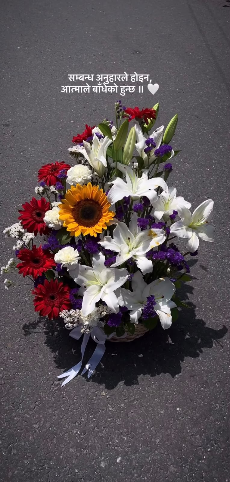 White Lilies: 8 blooms (some fully open, some partially open) Sunflower: 1 bloom Red Gerberas: 5 blooms White Carnations: 5 blooms