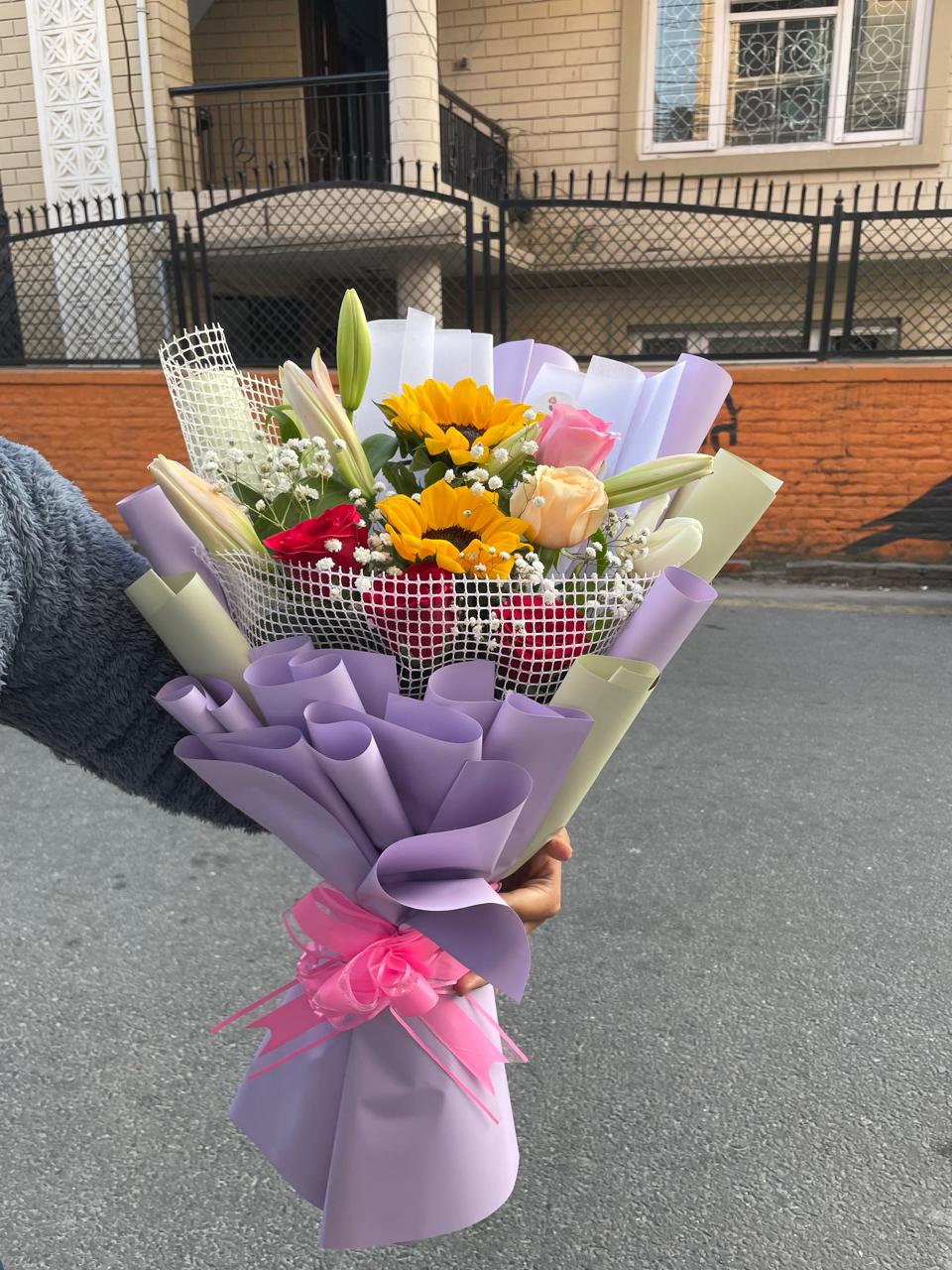 Buy Sunflower, Lily & 15 Mixed Rose Net Wrapped Bouquet Make a grand statement with our premium mixed bouquet of sunflowers, fragrant lilies, and 15 colorful roses, elegantly encased in luxury net wrapping. Order fresh today!