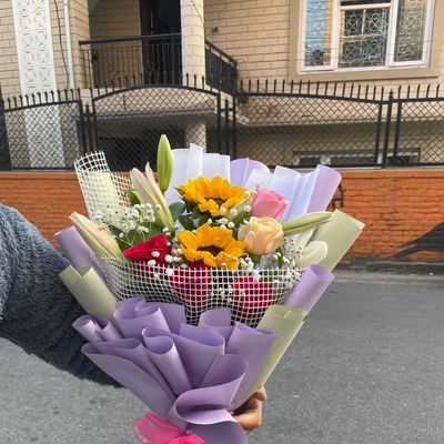 The Radiant Symphony – Premium Sunflower, Lily & Mixed Rose Net Bouquet