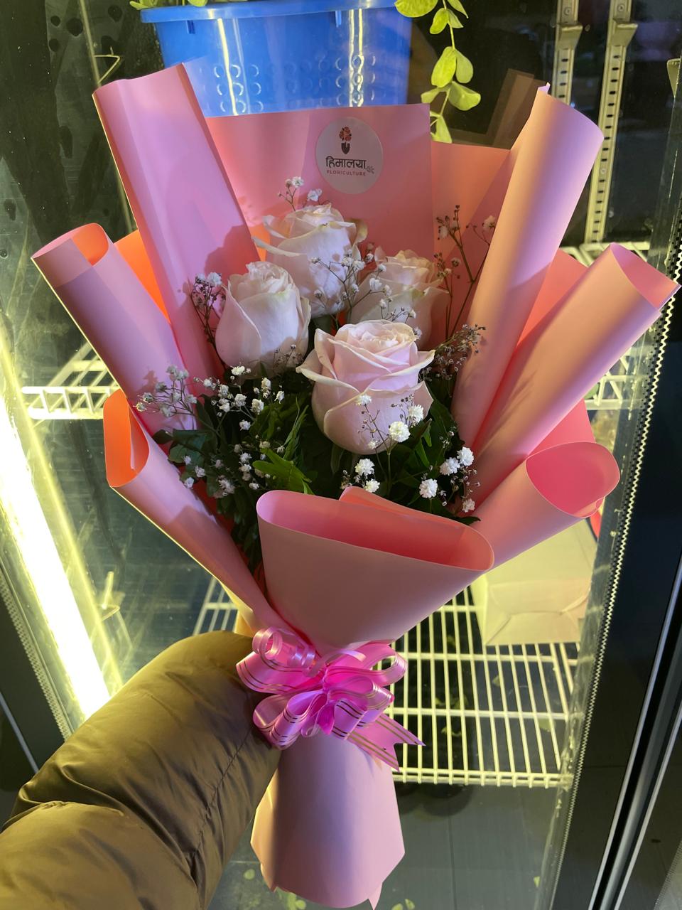 Expertly arranged as a neat, compact hand-tied bouquet accented with fresh seasonal greenery for a touch of volume and grace.