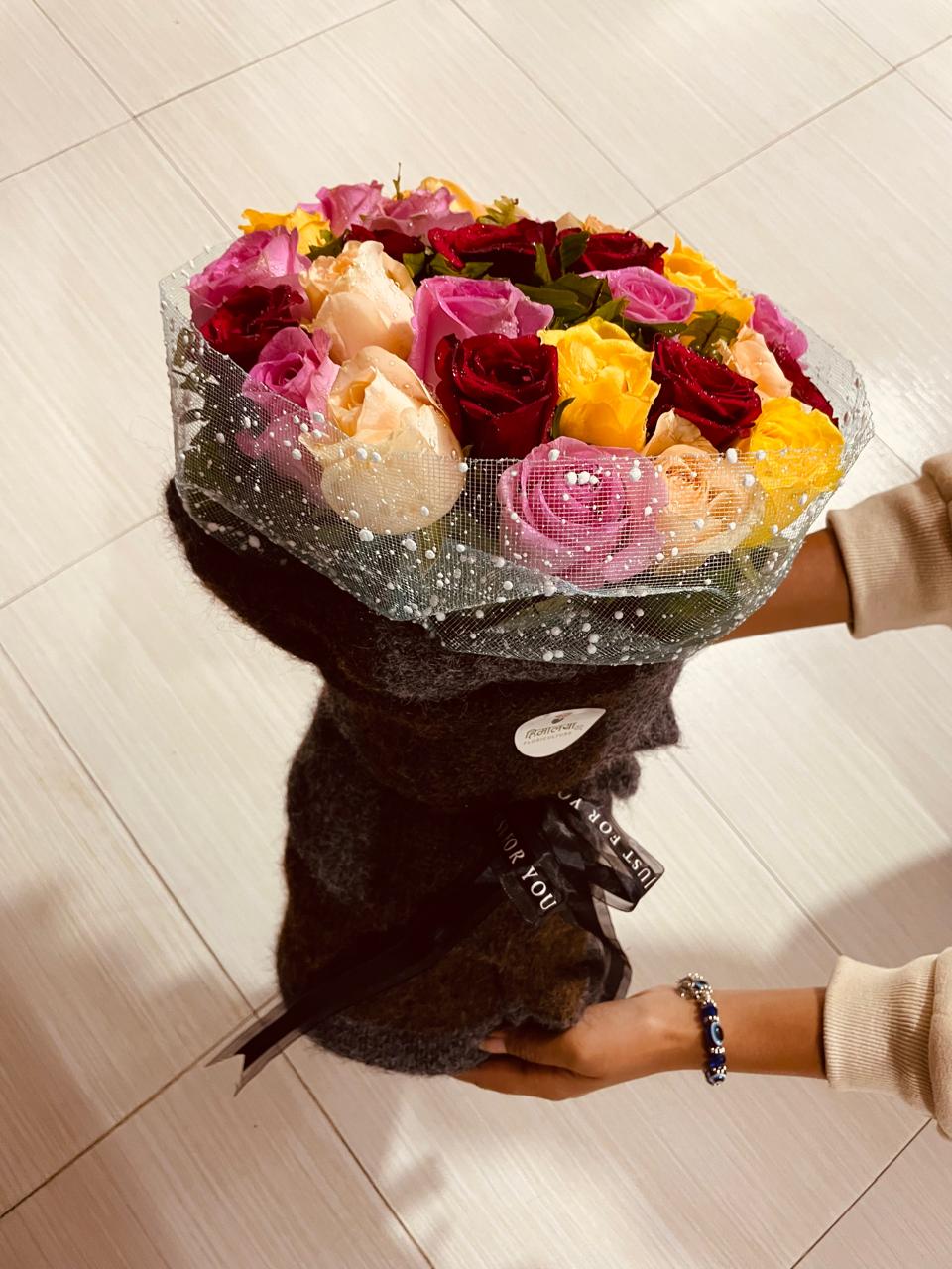 The Multicolor Sweater Edit (30 Stems) A trendy, modern bouquet matching 30 bold multi-colored roses with a chic sweater-textured outer wrap.