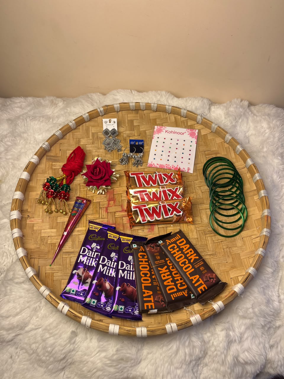 This combo is delivered without a naglo (traditional tray). Product colors, designs, and styles of accessories may vary slightly depending on availability while maintaining the overall quality and value of the combo. Chocolates are packed with care to ensure freshness; however, slight melting may occur during transit in hot weather. This festive combo is perfect for celebrating Shrawan, Teej, and other special occasions or for gifting your loved ones