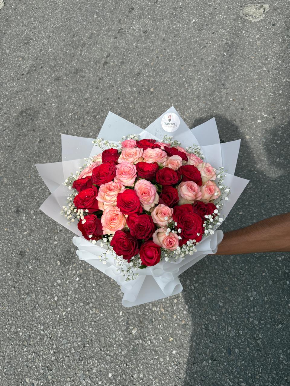As flowers are natural products, the size, bloom stage, and shades of pink and red may vary slightly depending on seasonal availability. The wrapping style may differ while maintaining the bouquet's premium appearance and overall elegance. To keep your roses fresh for longer, place them in clean water, trim the stems at an angle, and keep the bouquet away from direct sunlight and excessive heat.