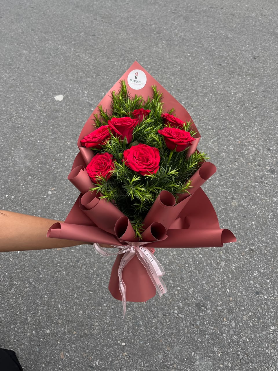 As flowers are natural products, the size, bloom stage, and shades of flowers may vary slightly depending on seasonal availability. Green leaves used as fillers may be replaced with other suitable green foliage based on availability while maintaining the bouquet's overall design and premium appearance. The wrapping style may also vary slightly while ensuring an elegant presentation. To keep the roses fresh for longer, place them in clean water and keep the bouquet away from direct sunlight and excessive heat.