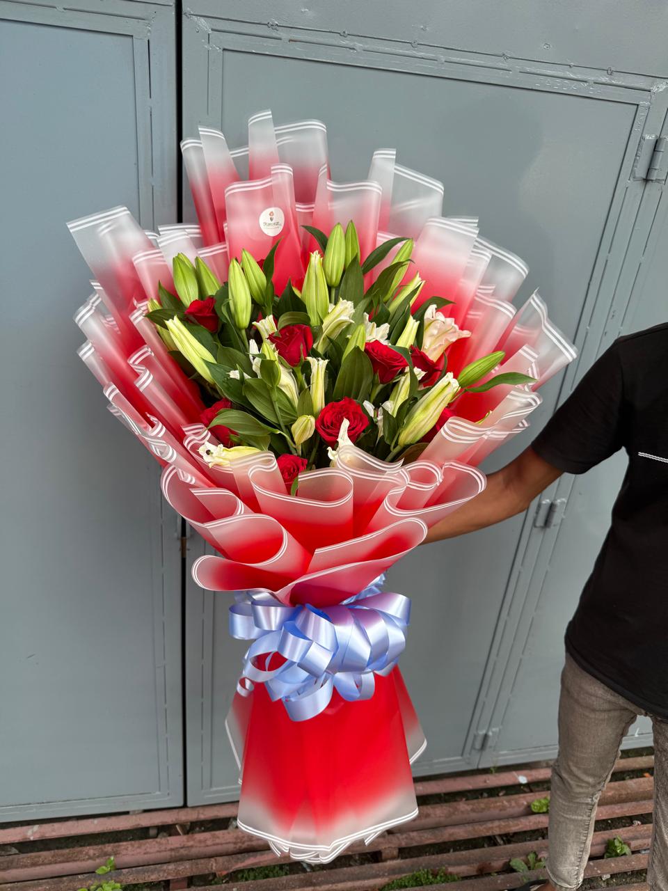 As flowers are natural products, the size, bloom stage, and shades of flowers may vary slightly depending on seasonal availability. The number of blooms on each lily stem may vary naturally. The wrapping style may also differ slightly based on availability while maintaining the bouquet's premium appearance and elegant presentation. To keep the flowers fresh for longer, place them in clean water and keep the bouquet away from direct sunlight and excessive heat.