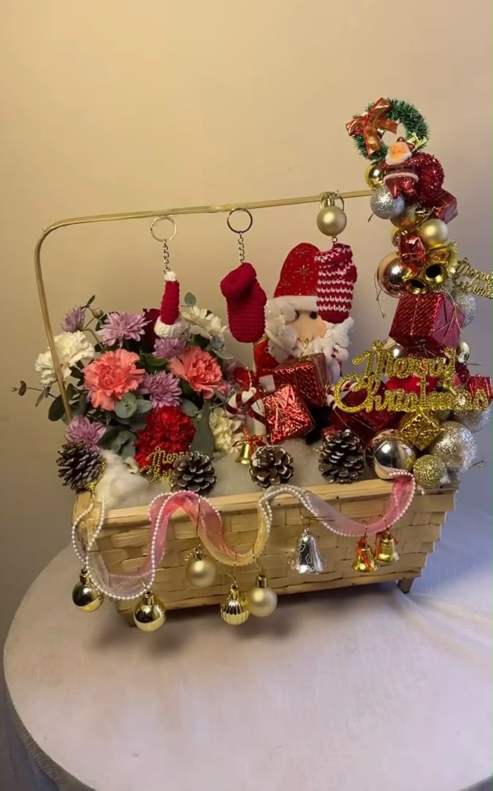 Christmas props, flower varieties, and bloom stages may vary depending on availability. In case any flower, decoration, or basket material is unavailable, a suitable replacement of similar value and style may be used while maintaining the festive look and premium presentation of the arrangement.
